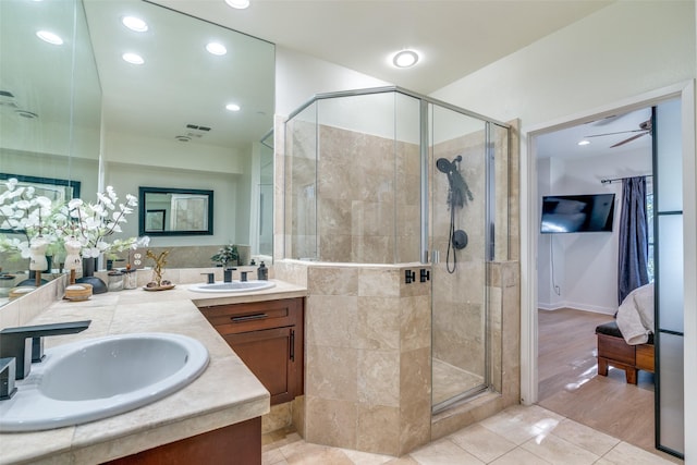 bathroom with walk in shower, ceiling fan, vanity, and tile patterned flooring