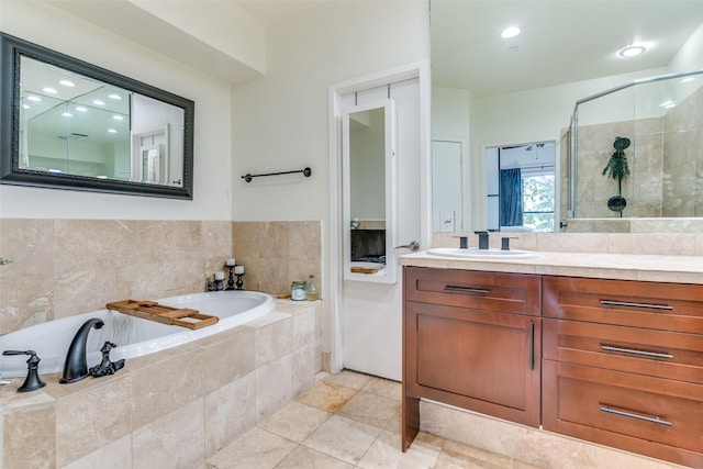 bathroom featuring tile patterned floors, vanity, and shower with separate bathtub