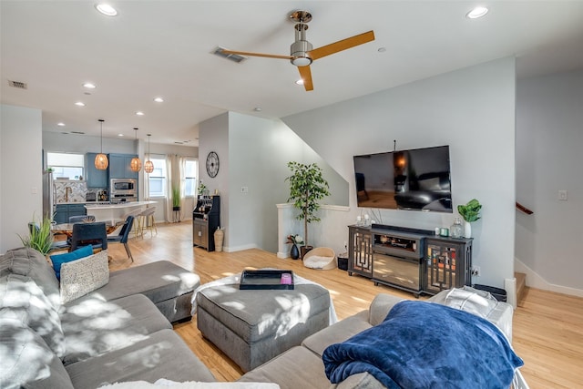 living room featuring ceiling fan and light wood-type flooring