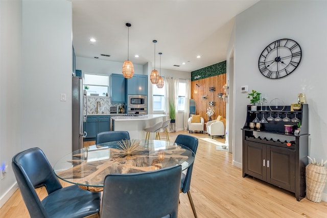 dining area with sink and light hardwood / wood-style flooring