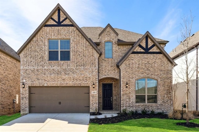 tudor house featuring a garage and a front yard