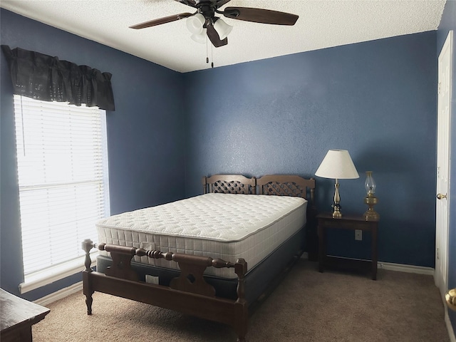 bedroom featuring ceiling fan, a textured ceiling, and dark colored carpet