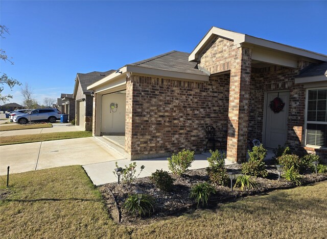 view of side of home featuring a garage and a lawn