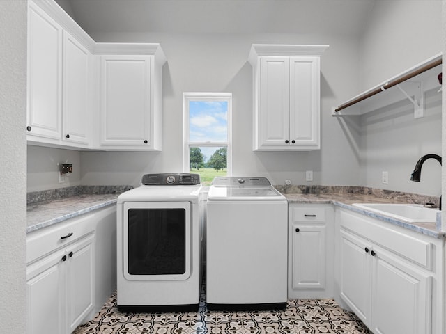 washroom with cabinets, sink, light tile patterned floors, and washer and clothes dryer