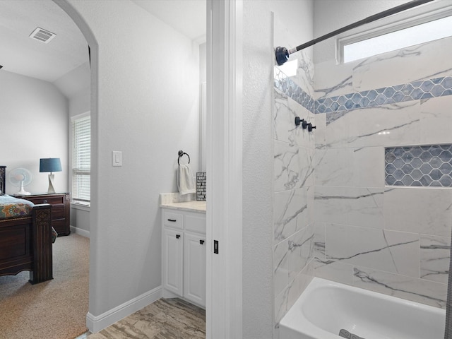 bathroom featuring vanity and tiled shower / bath