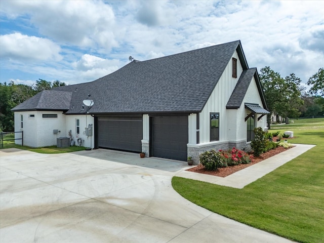 view of front of property featuring a garage, central AC unit, and a front lawn