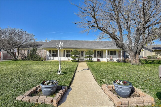 rear view of property with covered porch and a yard