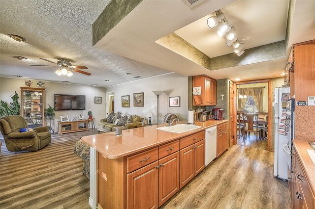 kitchen with a textured ceiling, white dishwasher, ceiling fan, sink, and light hardwood / wood-style floors