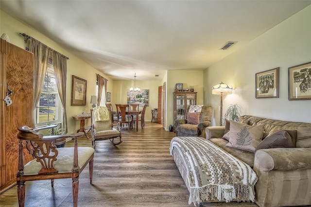 living room featuring hardwood / wood-style flooring and an inviting chandelier