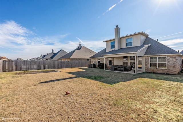 rear view of house featuring a patio, outdoor lounge area, cooling unit, and a lawn