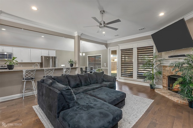 living room with dark wood-type flooring, ceiling fan, ornamental molding, and sink