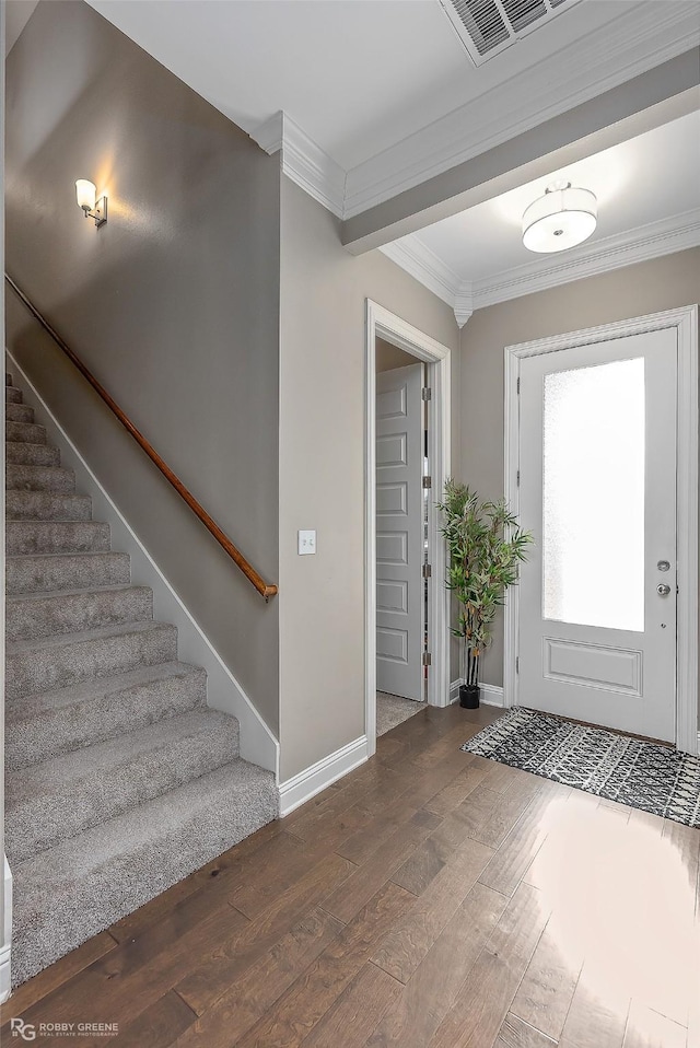 entryway with ornamental molding and dark wood-type flooring