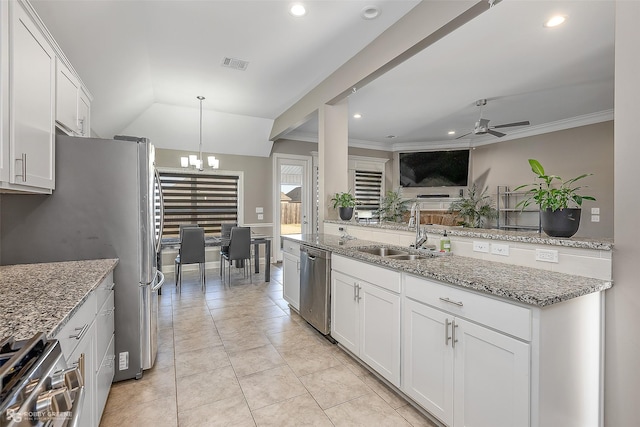 kitchen featuring sink, stainless steel appliances, light stone countertops, white cabinets, and decorative light fixtures