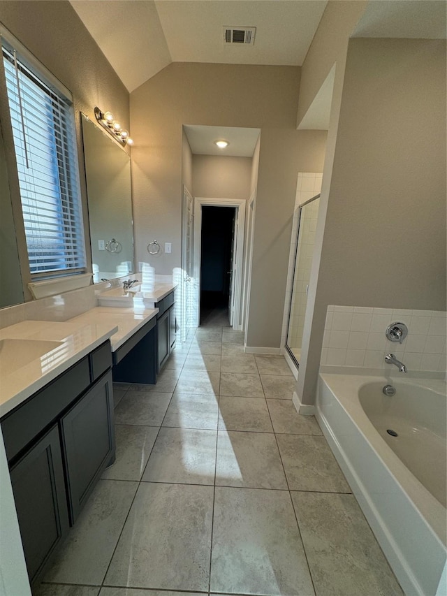 bathroom with tile patterned flooring, vanity, independent shower and bath, and vaulted ceiling