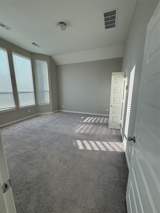 unfurnished room with lofted ceiling and carpet floors