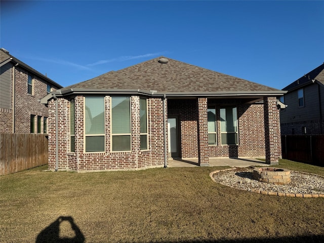 back of house with a lawn, a patio area, and an outdoor fire pit