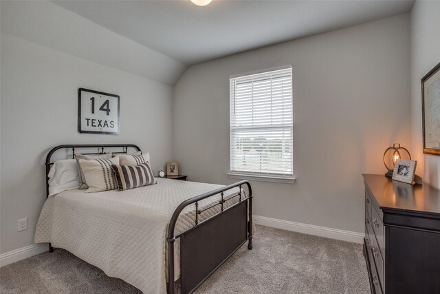 bedroom with vaulted ceiling and light colored carpet