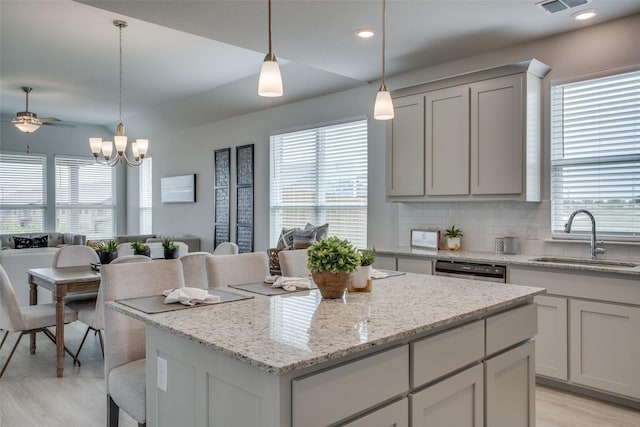 kitchen featuring pendant lighting, sink, a kitchen island, and a wealth of natural light