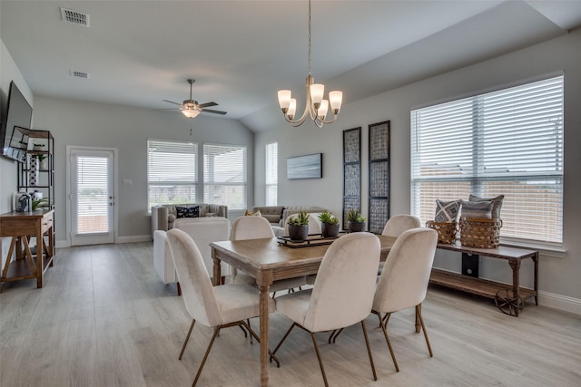 dining area featuring vaulted ceiling, ceiling fan with notable chandelier, and light hardwood / wood-style flooring