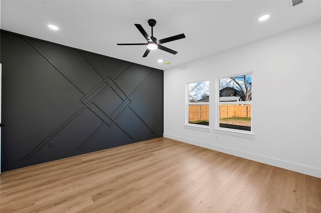 empty room featuring ceiling fan and light hardwood / wood-style floors