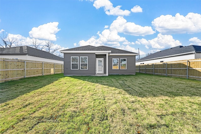 rear view of house featuring a yard