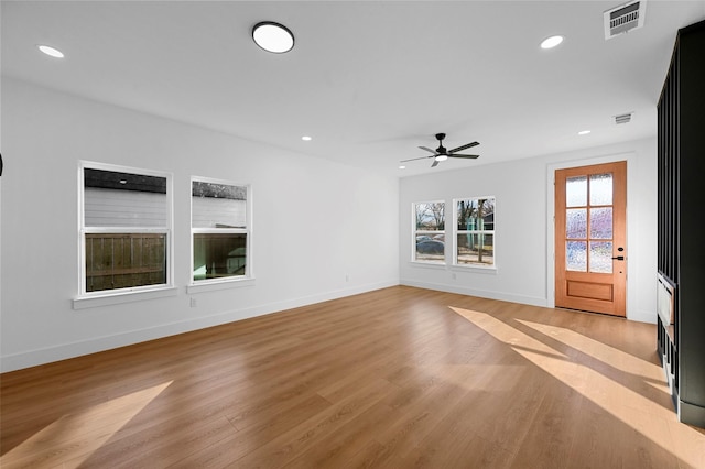 unfurnished living room featuring ceiling fan and light hardwood / wood-style flooring