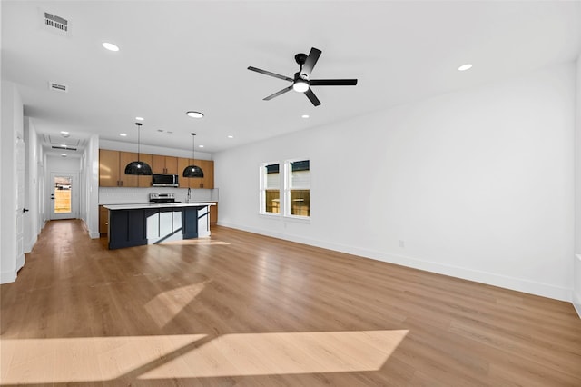 unfurnished living room with ceiling fan and light hardwood / wood-style flooring