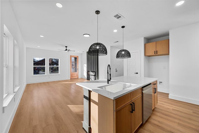 kitchen with ceiling fan, sink, decorative light fixtures, a center island with sink, and dishwasher