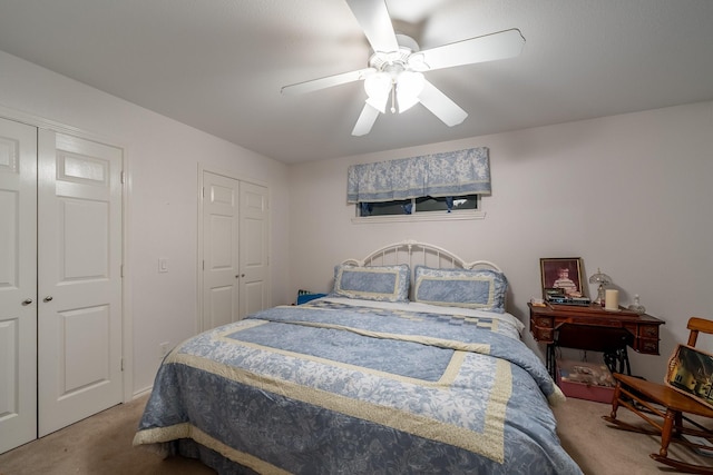 bedroom featuring carpet, ceiling fan, and multiple closets