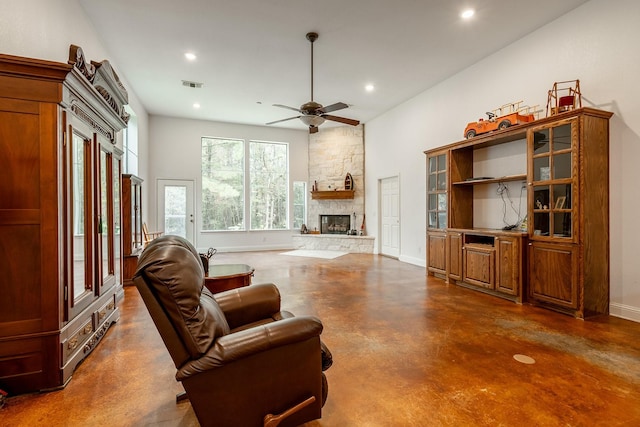 living room featuring a stone fireplace and ceiling fan