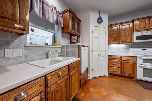 kitchen featuring white appliances, tasteful backsplash, and sink