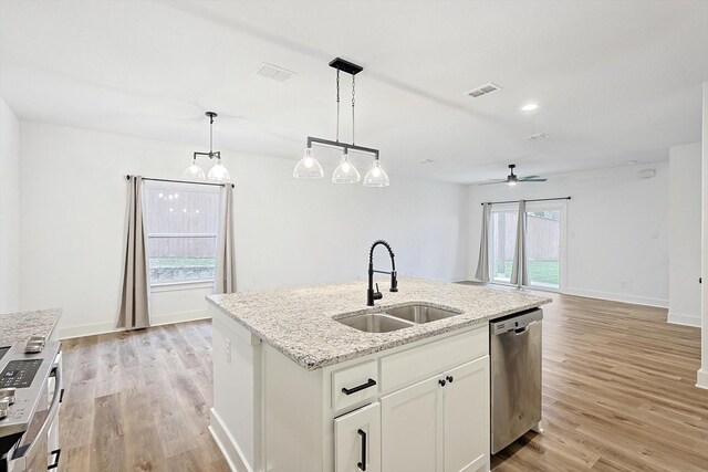 kitchen with sink, decorative light fixtures, dishwasher, an island with sink, and white cabinets