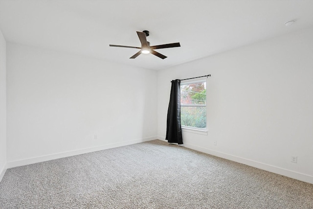 carpeted empty room with ceiling fan and baseboards