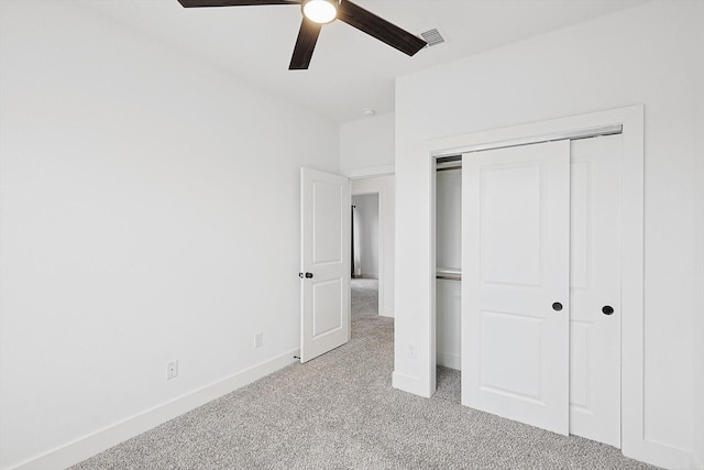 unfurnished bedroom with a closet, visible vents, a ceiling fan, light carpet, and baseboards