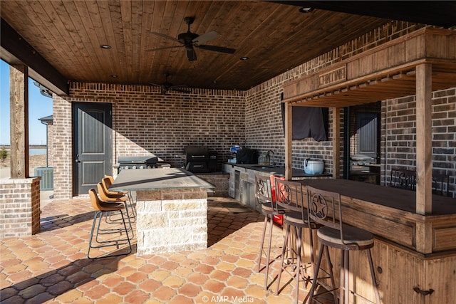 view of patio / terrace with ceiling fan, central AC unit, and a wet bar