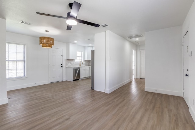 unfurnished living room with light hardwood / wood-style flooring, ceiling fan, and sink