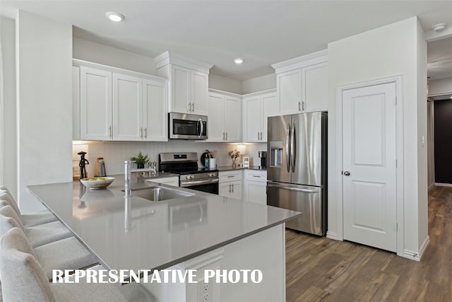 kitchen featuring white cabinetry, sink, kitchen peninsula, and stainless steel appliances