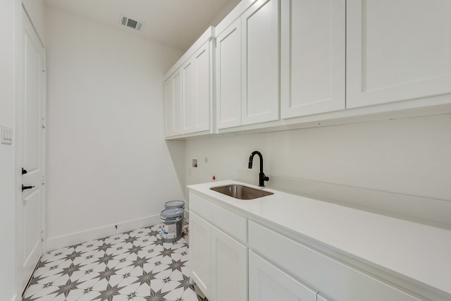 clothes washing area featuring washer hookup, sink, and cabinets