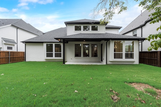 back of house with a patio and a lawn