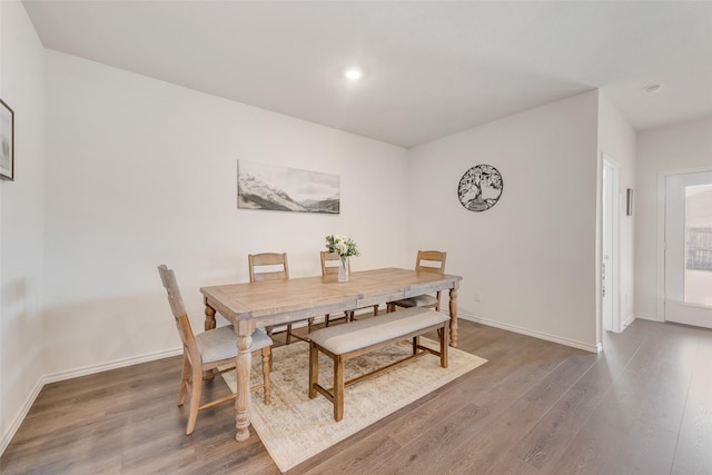 dining space featuring baseboards, wood finished floors, and recessed lighting