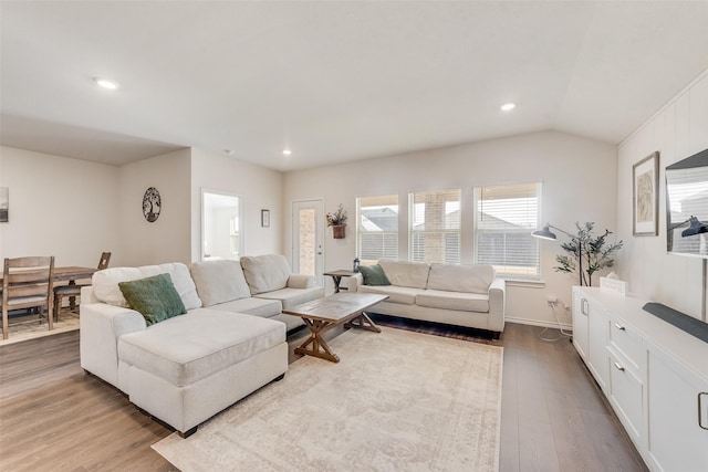 living area featuring light wood-style floors, recessed lighting, and vaulted ceiling