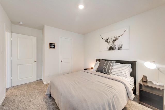 bedroom featuring light carpet and baseboards