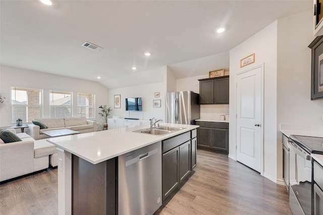 kitchen featuring sink, a center island with sink, light hardwood / wood-style floors, and appliances with stainless steel finishes