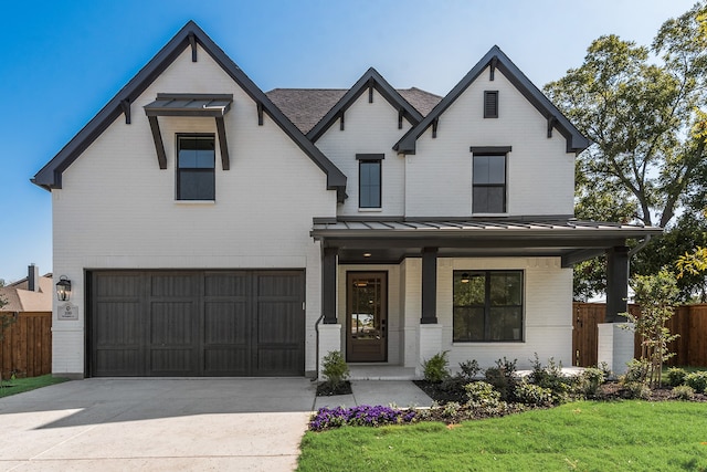 modern farmhouse with a porch, a garage, and a front lawn