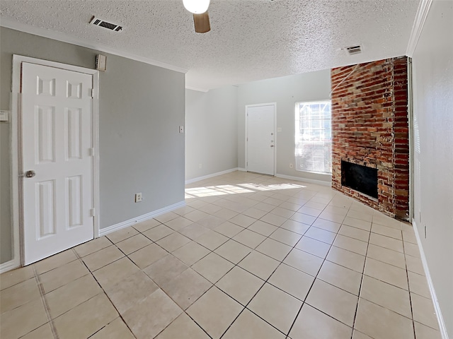 unfurnished living room featuring a brick fireplace, ceiling fan, ornamental molding, light tile patterned floors, and a textured ceiling