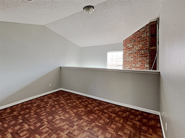 unfurnished room featuring a textured ceiling, dark parquet floors, and vaulted ceiling