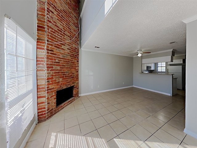 unfurnished living room with light tile patterned flooring, a textured ceiling, ceiling fan, and a fireplace