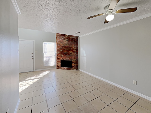 unfurnished living room featuring ceiling fan, light tile patterned flooring, a textured ceiling, and a brick fireplace