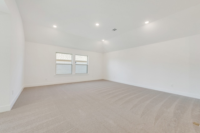 spare room with lofted ceiling and light carpet