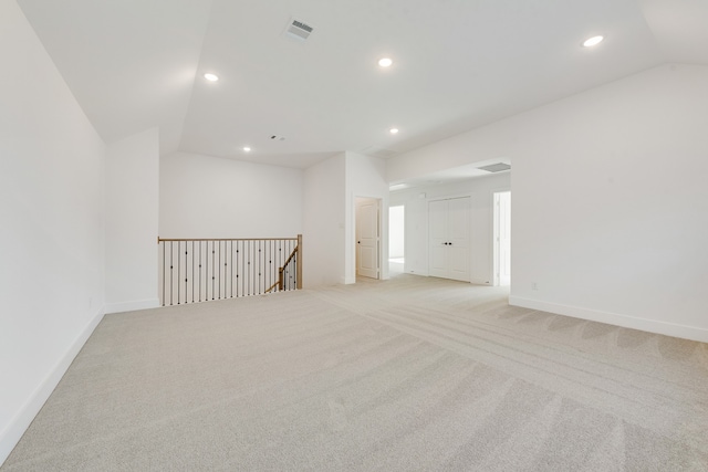 carpeted empty room with lofted ceiling